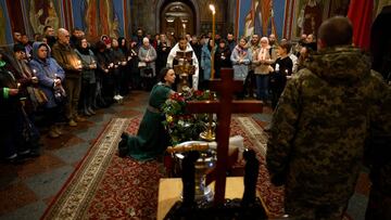 KYIV, UKRAINE - NOVEMBER 16:  Yevheniia Kolesnichenko grieves during her husband's funeral in Saint Michael's Golden-Domed Monastery for father of three children Evheniy Kolesnichenko who was killed on 24th of February during deployment near Bakhmut, Donetsk district on November 16, 2022 in Kyiv, Ukraine. Nearly nine months has passed since Russia invaded Ukraine and, although Ukraine has regained territory in recent weeks, the war shows no signs of letting up. (Photo by Jeff J Mitchell/Getty Images)