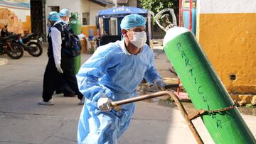 A health worker transports an oxygen tank at the Cesar Garayar support hospital in the city of Iquitos, in the Amazon basin on May 22, 2020 which usually tends victims of endemic diseases like dengue, malaria, chikunguya and leptospirosis that still affect the population in addition to the arrival of the novel coronavirus that has claimed the lives of 14 doctors at this facility, not dedicated to harbor Covid19 cases. - Focused attention on fighting the new coronavirus in Peru has detracted the ability to combat the dengue fever, an explosive situation in the Amazon region, where it is leaving a trail of disease and death in cities and remote indigenous villages. (Photo by Cesar Von BANCELS / AFP)