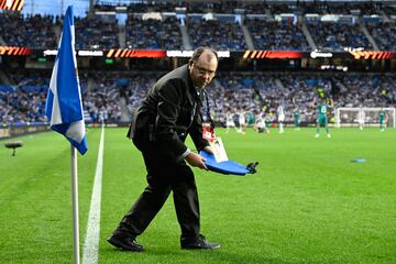 Un empleado de seguridad del club de San Sebastián retira los asientos lanzados desde la zona donde se encontraban los ultras del equipo belga.