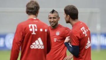 El centrocampista chileno Arturo Vidal (c) conversa con el centrocampista espa&ntilde;ol Xabi Alonso (d) y el delantero Thomas M&uuml;ller (i) durante el entrenamiento del Bayer de M&uacute;nich