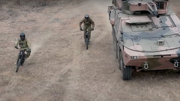 Dos soldados montan sus MTB el&eacute;ctricas junto a un tanque del ej&eacute;rcito australiano. 