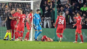 Joan Jordán, jugador del Sevilla FC, se duele en el suelo tras el lanzamiento de un palo desde la grada.