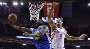 Draymond Green salta para encestar delante de Michael Beasley.