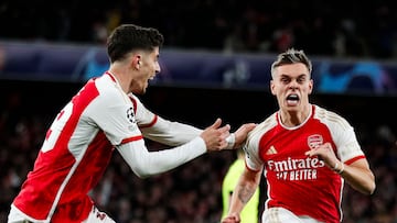 Arsenal's Belgian midfielder #19 Leandro Trossard (R) celebrates after scoring his team second goal during the UEFA Champions League quarter final first-leg football match between Arsenal and Bayern Munich at the Arsenal Stadium, in north London, on April 9, 2024. (Photo by Ian Kington / IKIMAGES / AFP)