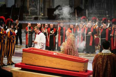 El cardenal camarlengo Kevin Joseph Farrell (centro derecha) esparce incienso alrededor del cuerpo del papa Francisco en la Basílica de San Pedro del Vaticano.
