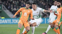 Real Betis' Spanish forward Ayoze Perez (L) fights for the ball with Elche's Chilean defender Enzo Roco during the Spanish League football match between Elche CF and Real Betis at the Martinez Valero stadium in Elche, on February 24, 2023. (Photo by Jose Jordan / AFP)