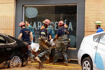 Los equipos de emergencias sacan un cuerpo sin vida, después de que fuera encontrado en un estacionamiento en Catarroja, Valencia. 