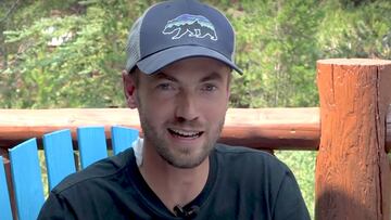 El trail runner Tom Whitney, con una gorra de un oso y el bosque al fondo, explicando su encuentro con un oso grizzly en Island Park (Idaho, Estados Unidos).