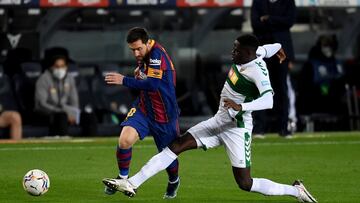 BARCELONA, SPAIN - FEBRUARY 24: Lionel Messi of FC Barcelona is tackled by Omenuke Mfulu of Elche CF during the La Liga Santader match between FC Barcelona and Elche CF at Camp Nou on February 24, 2021 in Barcelona, Spain. Sporting stadiums around Spain r