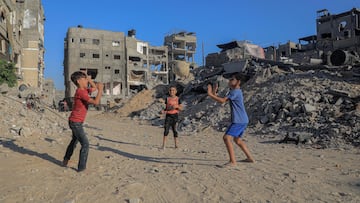 Tres niños palestino juegan con un balón entre las ruinas de los edificios derrumbados por las bombas de Israel en la Franja de Gaza.