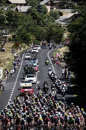 El pelotón adelantando a los vehículos de equipo que transportan las bicicletas. 