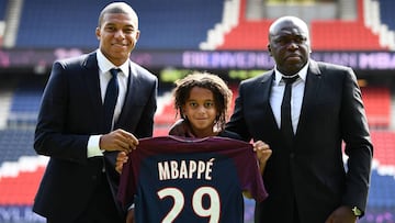 Ethan Mbappé, hermano pequeño de Kylian Mbappé, posa con la camiseta del PSG en la presentación de su hermano mayor.