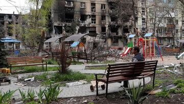 A man sits on a bench in front of a residential building heavily damaged during Ukraine-Russia conflict in the southern port city of Mariupol, Ukraine April 21, 2022. REUTERS/Alexander Ermochenko