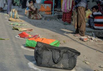 People put their bags in circles marked on the ground to maintain social distancing as they queue for free food rations at a government store during a government-imposed nationwide lockdown as a preventive measure against the COVID-19 coronavirus, in Sili