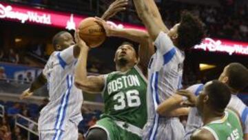 Marcus Smart penetra entre Victor Oladipo (izquierda) y Elfrid Payton (derecha).