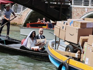 Un gondolero rema en una gndola con maniques que representan al fundador de Amazon, Jeff Bezos, y a su prometida, Lauren Snchez, con atuendos de boda, como parte de una parodia del colectivo artstico Konn Artiss.