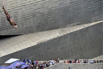 Un concursante se zambulle desde una plataforma de 27 metros en el puente La Salve que domina el Museo Guggenheim durante las finales de la serie Red Bull Cliff Diving en Bilbao. 