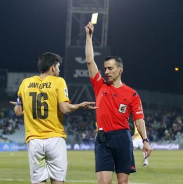 El árbitro Jaime Latre muestra la cartulina amarilla a Javi López.