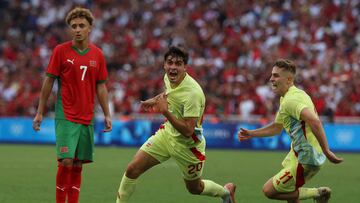 Spain's defender #20 Junlu Sanchez (C) celebrates with Spain's midfielder #11 Fermin Lopez (R) past Morocco's forward #07 Eliesse Ben Seghir after scoring his team's second goal during the men's semi-final football match between Morocco and Spain of the Paris 2024 Olympic Games at the Marseille Stadium in Marseille on August 5, 2024. (Photo by Pascal GUYOT / AFP)