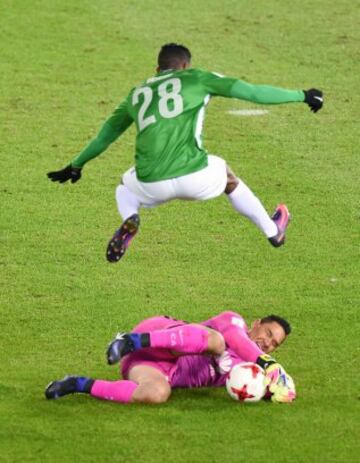 Atletico Nacional forward Orlando Berrio (top) jumps over Club America goalkeeper Moises Munoz during the Club World Cup third-place playoff football match between Atletico Nacional of Colombia and Club America of Mexico at Yokohama International stadium in Yokohama on December 18, 2016. / AFP PHOTO / Toru YAMANAKA