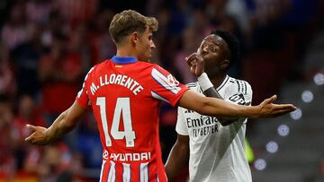 Real Madrid's Brazilian forward #07 Vinicius Junior discusses with Atletico Madrid's Spanish midfielder #14 Marcos Llorente during the Spanish league football match between Club Atletico de Madrid and Real Madrid CF at the Metropolitano stadium in Madrid on September 29, 2024. (Photo by OSCAR DEL POZO / AFP)