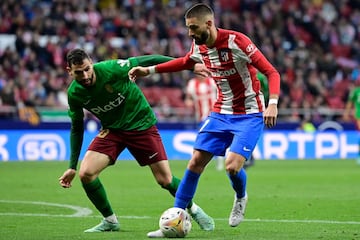 El delantero español de Granada Antonio Puertas (L) lucha por el balón con el centrocampista belga del Atlético de Madrid Yannick Ferreira-Carrasco.