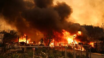 Smoke and flames rise from burning structures as powerful winds fueling devastating wildfires in the Los Angeles area force people to evacuate, at the Eaton Fire in Altadena, California, U.S. January 8, 2025. REUTERS/David Swanson