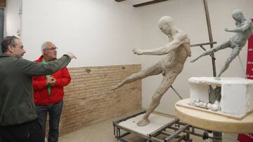 El artista Javi Molina explica a José Antonio Iniesta, padre de Andrés Iniesta, el proceso de creación de la escultura de su hijo en su taller de Valencia.