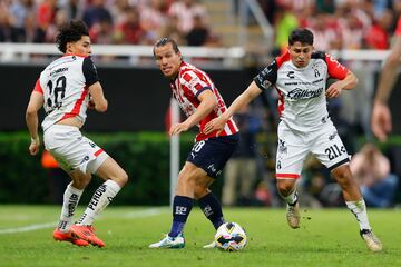 AME005. GUADALAJARA (MÉXICO), 21/11/2024.- Fernando González (i) de Guadalajara disputa el balón con Jeremy Márquez (i) y Israel Larios de Atlas este jueves, durante un partido de reclasificación del torneo apertura 2024 de la liga del fútbol mexicano entre Guadalajara y Atlas, en el Estadio Akron, en la ciudad de Guadalajara, Jalisco (México). EFE/ Francisco Guasco
