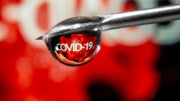 FILE PHOTO: The word "COVID-19" is reflected in a drop on a syringe needle in this illustration taken November 9, 2020. REUTERS/Dado Ruvic/Illustration/File Photo