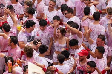 Personas se reúnen para celebrar durante el "Chupinazo", que marca el inicio oficial de las Fiestas de San Fermín en la Plaza Consistorial, frente al Ayuntamiento de Pamplona