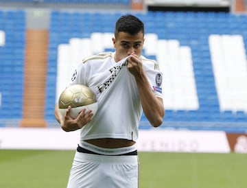 Reinier, vestido de blanco, posa para los medios en el césped del Santiago Bernabéu. 