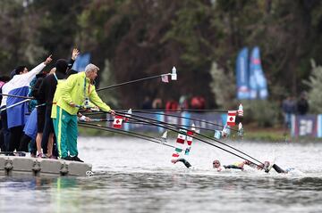 Esta curiosa imagen muestra la ingeniosa forma en la que varios miembros de distintos equipos entregan avituallamiento líquido a las nadadoras participantes en la prueba de aguas abiertas en los Juegos Panamericanos. Corresponde a la final femenina de 10 kilómetros, que tuvo lugar ayer en la Laguna Los Morros, al sur de Santiago de Chile.