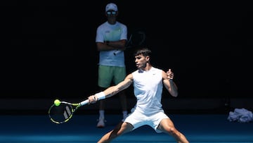 Samuel López supervisa desde el fondo de la pista un entrenamiento de Carlos Alcaraz en Melbourne.