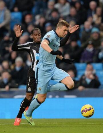 Vurnon Anita y Edin Dzeko disputan un balón. 