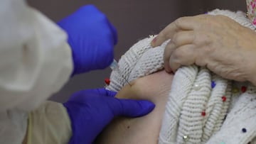 MADRID, 27/12/2020.- Una residente recibe una dosis de la vacuna contra la covid-19, este domingo, en la residencia de mayores Vallecas de Madrid. La Comunidad de Madrid inicia este domingo la campaña de vacunación contra el coronavirus con 1.200 dosis que serán administradas en tres residencias de personas mayores de la capital, justo un día después de notificar los primeros casos de la nueva variante británica del virus en España. EFE/JuanJo Martín