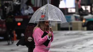 Una persona que lleva un paraguas camina por Time Square durante la lluvia en la ciudad de Nueva York el 23 de agosto de 2021. 