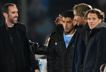 Uruguay's forward Luis Suarez (2nd L) greets former teammates (L to R) Diego Godin, Diego Lugano, and Diego Forlan during his farewell ceremony to the national team after the 2026 FIFA World Cup South American qualifiers football match between Uruguay and Paraguay at the Centenario stadium in Montevideo, on September 6, 2024. (Photo by Eitan ABRAMOVICH / AFP)