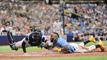 ST PETERSBURG, FLORIDA - AUGUST 27: Randy Arozarena #56 of the Tampa Bay Rays slides in to score against Kyle Higashioka #66 of the New York Yankees on a throwing error by Harrison Bader (not pictured) of the New York Yankees in the first inning at Tropicana Field on August 27, 2023 in St Petersburg, Florida. Julio Aguilar/Getty Images/AFP (Photo by Julio Aguilar / GETTY IMAGES NORTH AMERICA / Getty Images via AFP)
