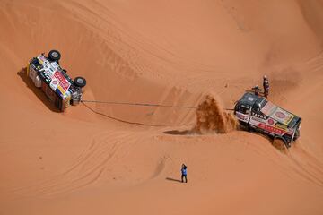 El piloto checo Jarosav Valtr y el copiloto Rene Kilian y Tomas Sikola son ayudados por el piloto checo Martin Soltys y el copiloto Ronan Krejci y David Hoffmann durante la décima etapa del Dakar.