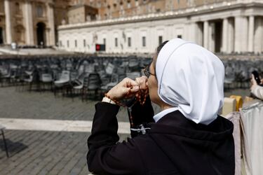 Una religiosa sostiene un rosario mientras observa al Papa Francisco durante su primera aparición pública en cinco semanas, el día de su alta del Hospital Gemelli, en una pantalla gigante en la Plaza de San Pedro, en el Vaticano.