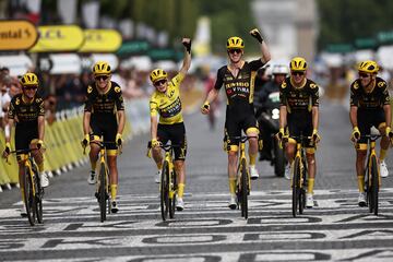 El ciclista danés de Jumbo-Visma, Jonas Vingegaard, con el maillot amarillo de líder general celebra su victoria general con sus compañeros de equipo mientras pedalea hacia la línea de meta después de la 21.ª y última etapa de la 110.ª