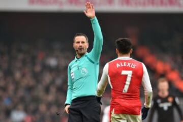 English referee Mark Clattenburg (L) gestures to Arsenal's Chilean striker Alexis Sanchez during the English Premier League football match between Arsenal and Hull City at the Emirates Stadium in London on February 11, 2017. / AFP PHOTO / Glyn KIRK / RESTRICTED TO EDITORIAL USE. No use with unauthorized audio, video, data, fixture lists, club/league logos or 'live' services. Online in-match use limited to 75 images, no video emulation. No use in betting, games or single club/league/player publications. /