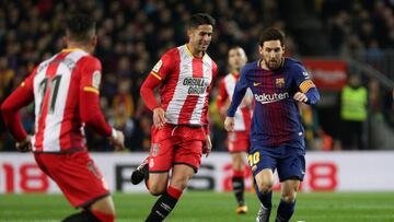 Juanpe con la camiseta del Girona peleando un bal&oacute;n a Messi. 