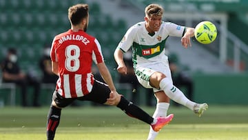 ELCHE, SPAIN - MAY 22: Lucas Boye of Elche CF passes the ball past Unai Lopez of Athletic Bilbao  during the La Liga Santander match between Elche CF and Athletic Club at Estadio Martinez Valero on May 22, 2021 in Elche, Spain. A limited number of fans wi