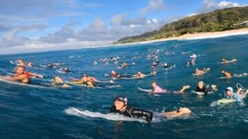 Un surfista se graba en POV surfeando una ola en Pipeline con decenas de surfistas delante remando hacia el pico y la isla de Oahu (Haw&aacute;i, Estados Unidos) detr&aacute;s, en diciembre del 2022. 