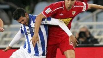 El mexicano de la Real Sociedad, Carlos Vela (i), lucha el balón con Manu del Moral, delantero del Sevilla CF, durante el partido, correspondiente a la décimo séptima jornada de Liga en Primera División, que juegan los dos equipos, esta noche, en el estadio de Anoeta, en San Sebastián.