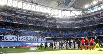 Los jugadores del Real Madrid y del Valladolid se saludan antes del inicio del encuentro con una pancarta de fondo que homenajea a Álvaro Arbeloa. 