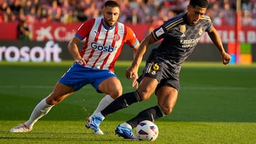 GIRONA, 30/09/2023.- El defensa del Girona David López (i) persigue a Jude Bellingham (d), del Real Madrid, durante el partido de la jornada 8 de Liga de Primera división que disputan el Girona y el Real Madrid, este sábado en el estadio de Montilivi, en Girona. EFE/David Borrat
