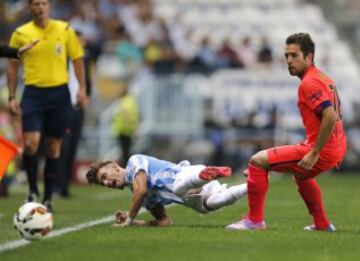El delantero del Málaga CF, Samuel Castillejo, cae tras la entrada del defensa del FC Barcelona Jordi Alba, durante el encuentro de la quinta jornada de Liga en Primera División que se disputa esta noche en el estadio de La Rosaleda, en Málaga.